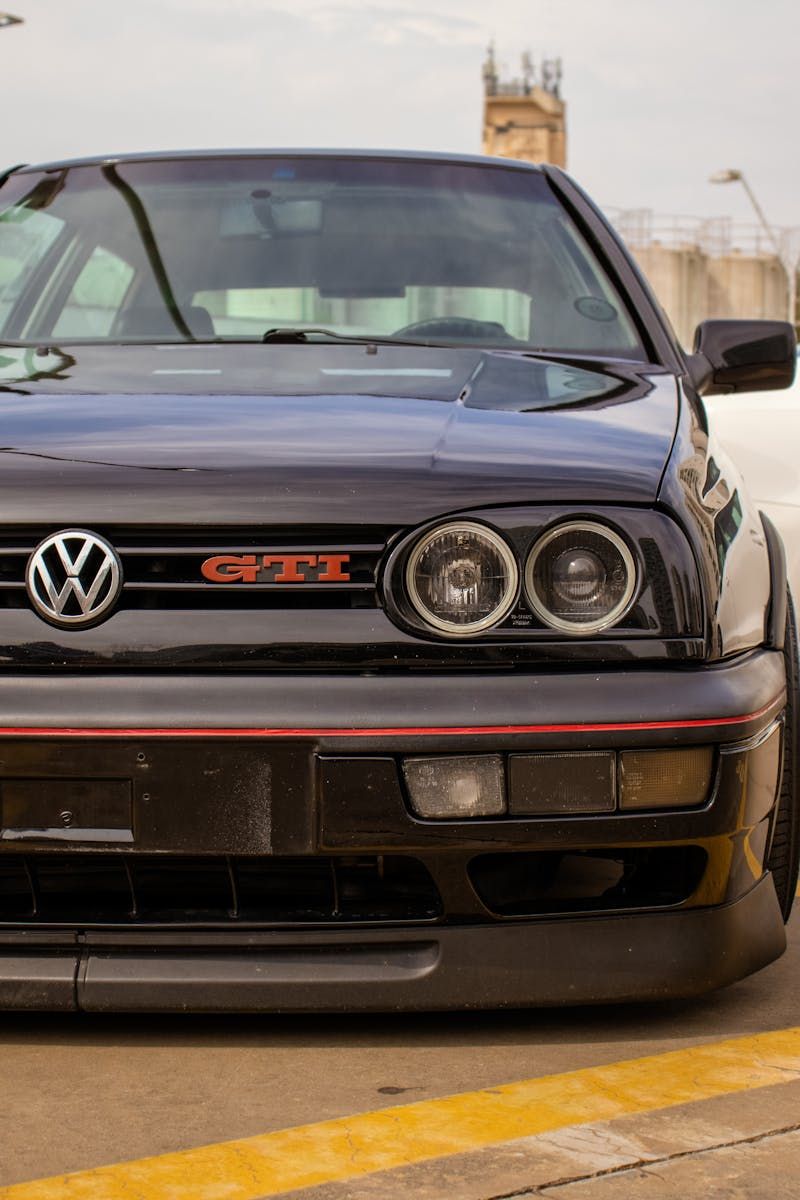Frontansicht eines schwarzen VW Golf GTI mit rotem GTI-Emblem im Kühlergrill
